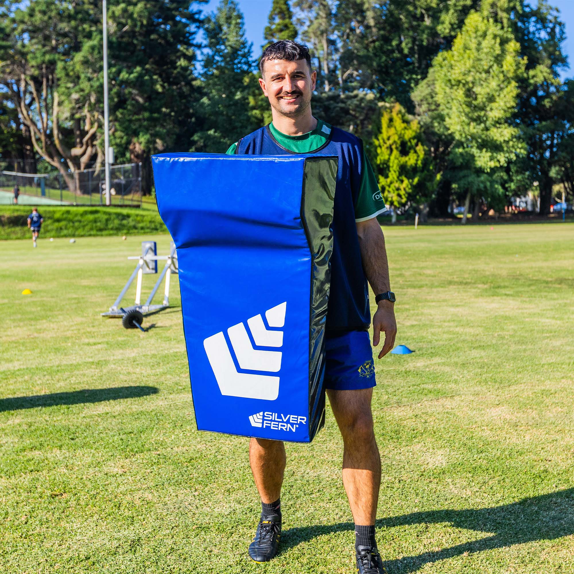 Hit Shield Deluxe Wedge, lifestyle shot, rugby player holding hit pad at chest level.