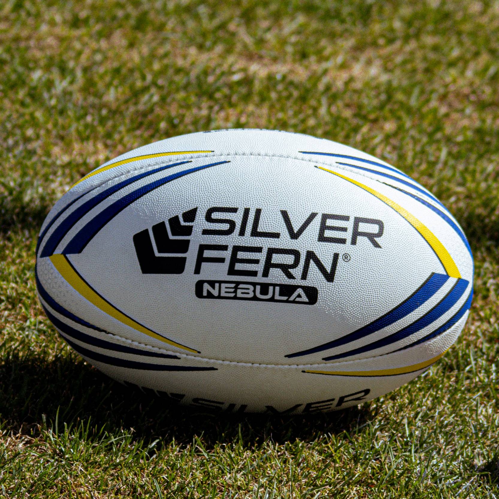 Silver Fern Nebula Premier Match Ball, lifestyle shot, sitting on a rugby field