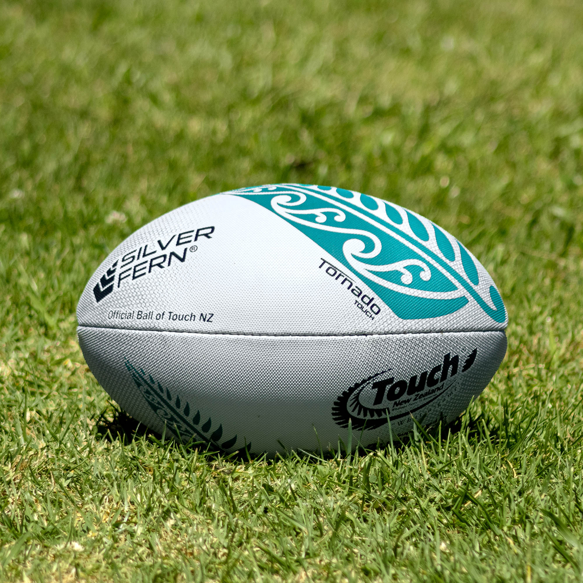 Silver Fern Tornado Touch Rugby Match Ball, Lifestyle shot, sitting on a rugby field