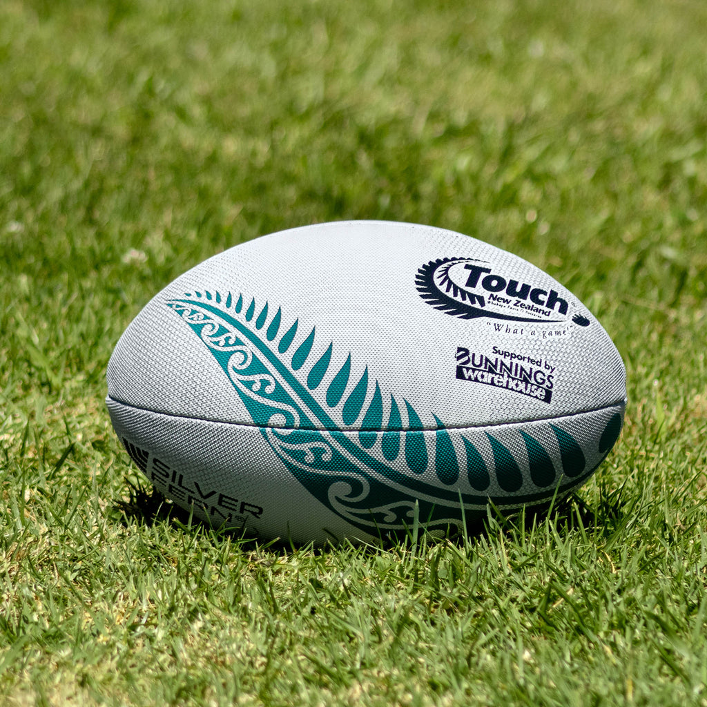 Silver Fern Tornado Touch Rugby Match Ball, Lifestyle shot, sitting on a rugby field